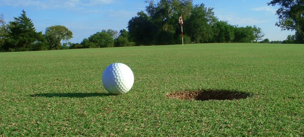 A golf ball teeters near the hole as apparently humankind does with the end of the world supposedly approaching